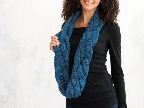 Braided Infinity Scarf — Crochet Scarf Patterns Braided Infinity Scarf Crochet Pattern in blue worn by a model — Crochet Scarf Patterns