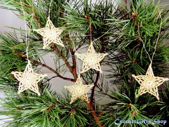 Crochet Star Ornaments — Crochet Christmas Ornaments Patterns Crochet Christmas star ornaments hanging on a pine tree branch. — Crochet Christmas Ornaments Patterns