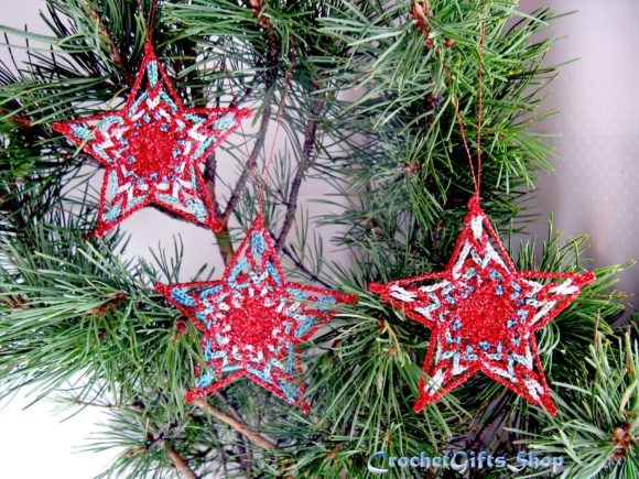 Crochet Star Christmas Ornaments — Crochet Christmas Ornaments Patterns Crochet Christmas star ornaments in red and blue hanging on greenery. — Crochet Christmas Ornaments Patterns