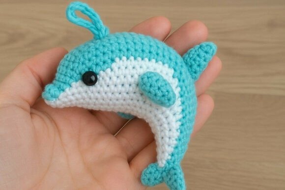 Cute Amigurumi Dolphin — cute amigurumi patterns Cute amigurumi dolphin in hand — cute amigurumi patterns