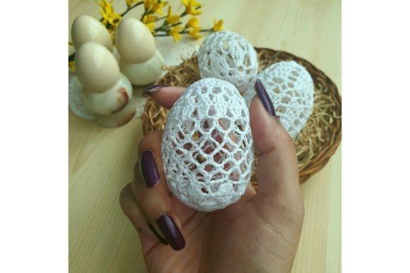 Lace Crochet Easter Egg — crochet Easter patterns Hand holding a delicate white lace crochet Easter egg with more eggs and yellow flowers in the — crochet Easter patterns