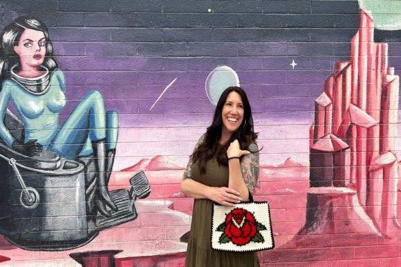 Rose Tattoo Crochet Bag — crochet tote bags patterns Crochet tote bag with rose motif against a colorful mural background. — crochet tote bags patterns