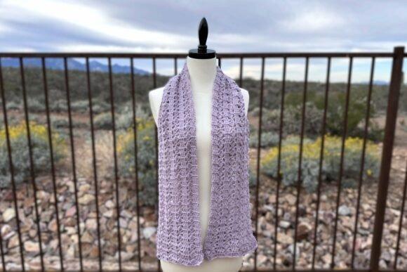 Slanting Squares Scarf — Crochet Scarf Patterns Crochet scarf in light purple color, displayed on a mannequin outdoors. — Crochet Scarf Patterns
