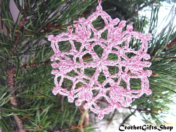 Crochet Snowflake Ornament — Crochet Christmas Ornaments Patterns Crochet snowflake ornament in pink yarn hanging on a pine branch. — Crochet Christmas Ornaments Patterns