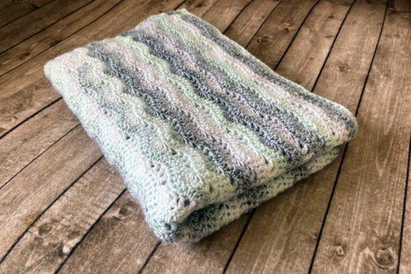 Snuggle Baby Blanket — cozy crochet blanket patterns Cozy crochet blanket in soft colors on wooden surface — cozy crochet blanket patterns