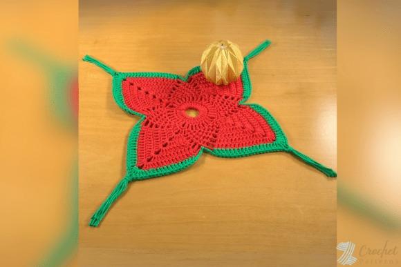 Festive Christmas Doily — Christmas Crochet Patterns Christmas doily crochet pattern in red and green with a decorative ornament on top — Christmas Crochet Patterns