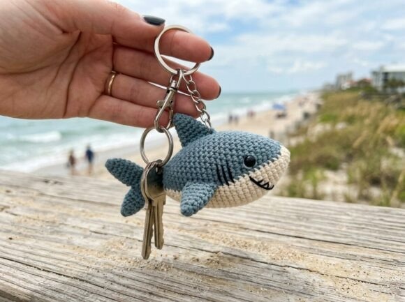 Crochet Amigurumi Shark Keychain — crochet amigurumi keychain Crochet amigurumi keychain of a shark held by a hand near the beach.