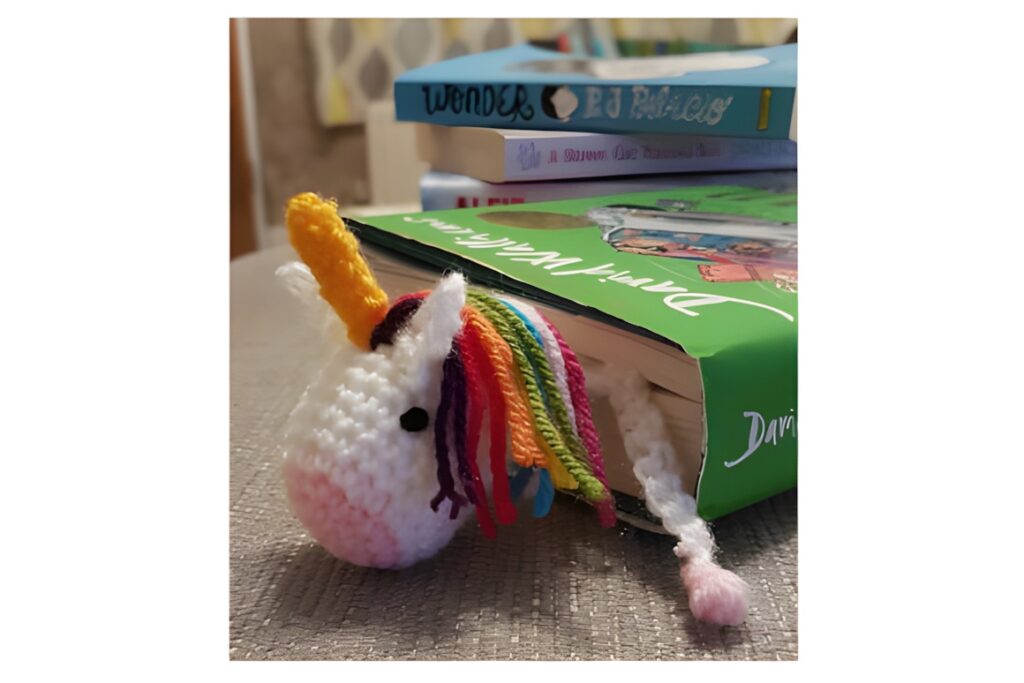 Small Crochet Projects: Unicorn Bookmark peeking from a book