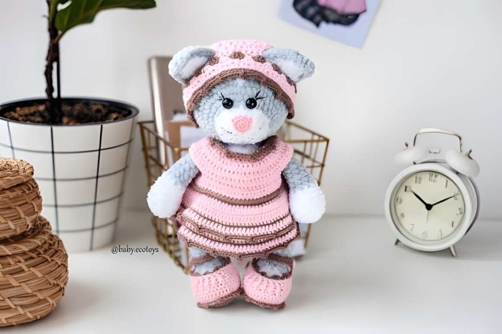 Amigurumi crochet cat pattern showcasing a cute cat doll in a pink outfit. — amigurumi crochet patterns