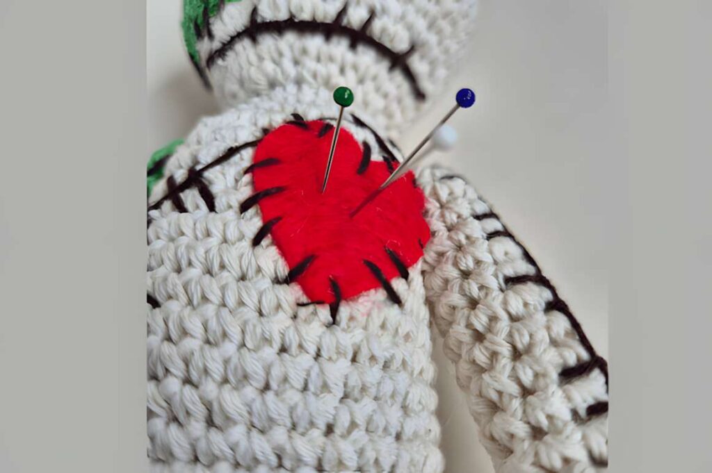 Amigurumi Voodoo Doll with pins, showcasing unique crochet design. — amigurumi crochet patterns
